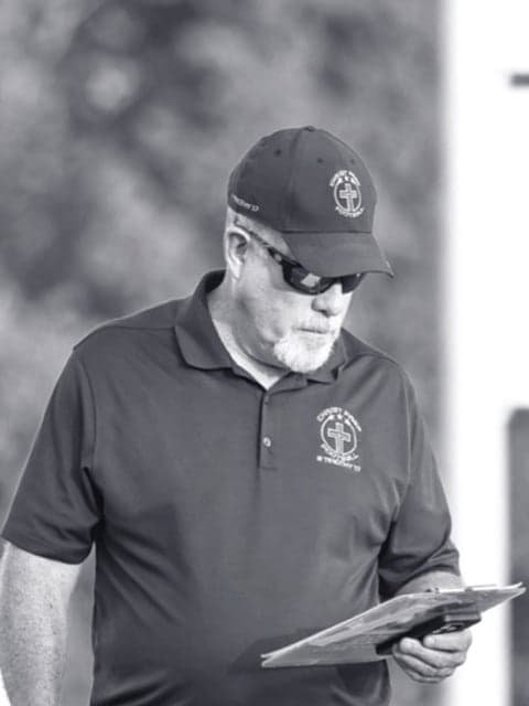 Christ Prep Football's head coach walking the sideline with his clipboard
