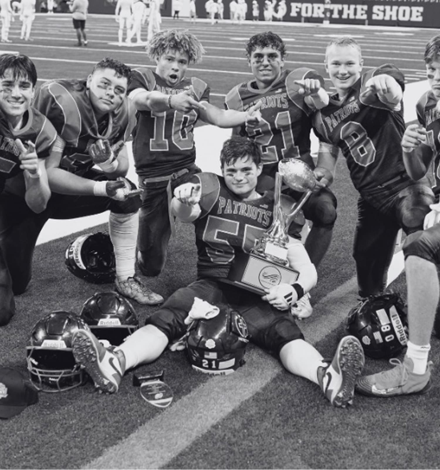 Christ Prep Football players with the championship trophy after the game
