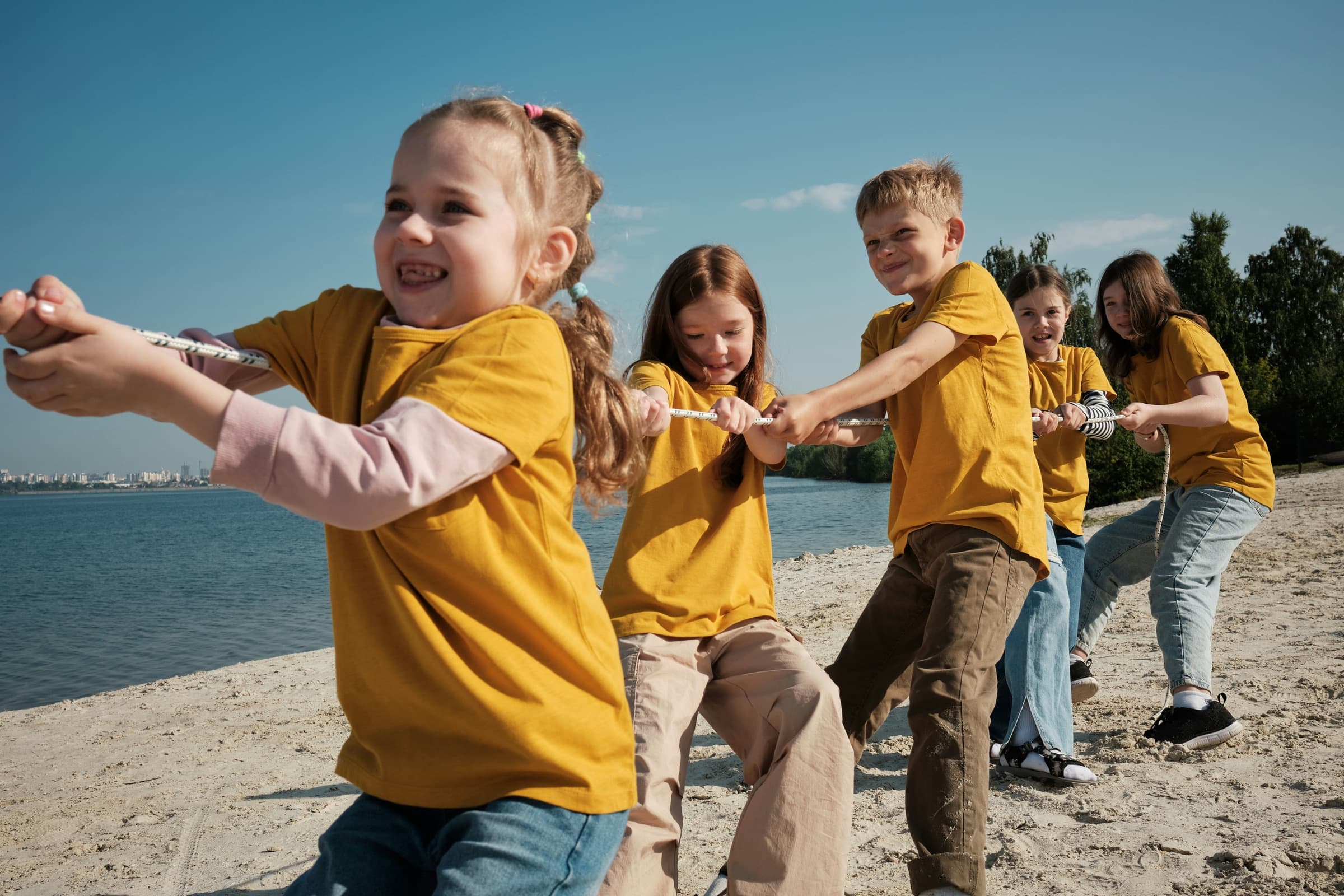 Kids playing tug-of-war on a beach